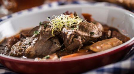 Zu sehen ist das Beitragsbild zum Rezept mit dem Titel: Wildschweinbraten mit Karottenpilzen dazu ein Baguette als Beilage